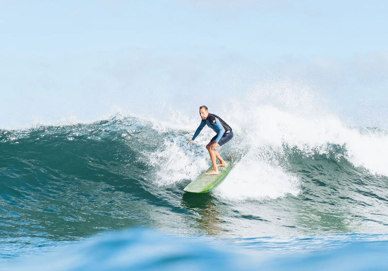 Surfeur sur une vague avec un longboard