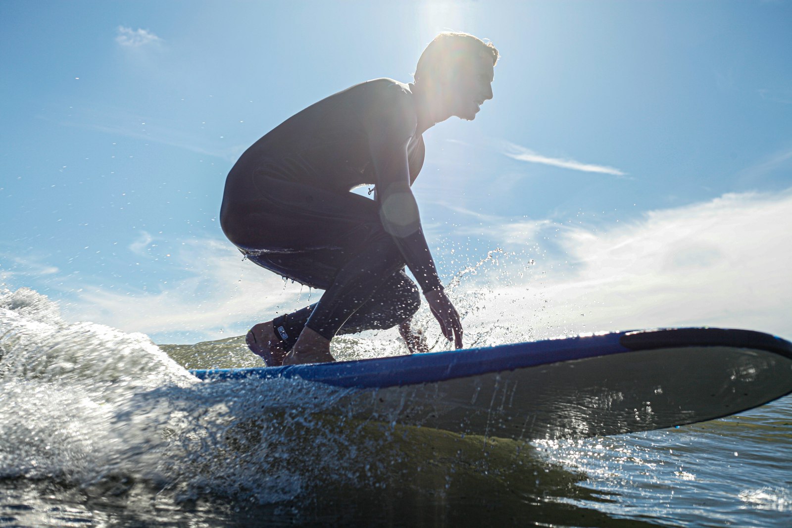 Surfeur en combinaison néoprène sur une vague